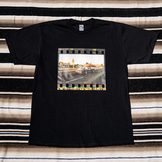 A black t-shirt with a photograph of a car on Washington Blvd printed in the center.
