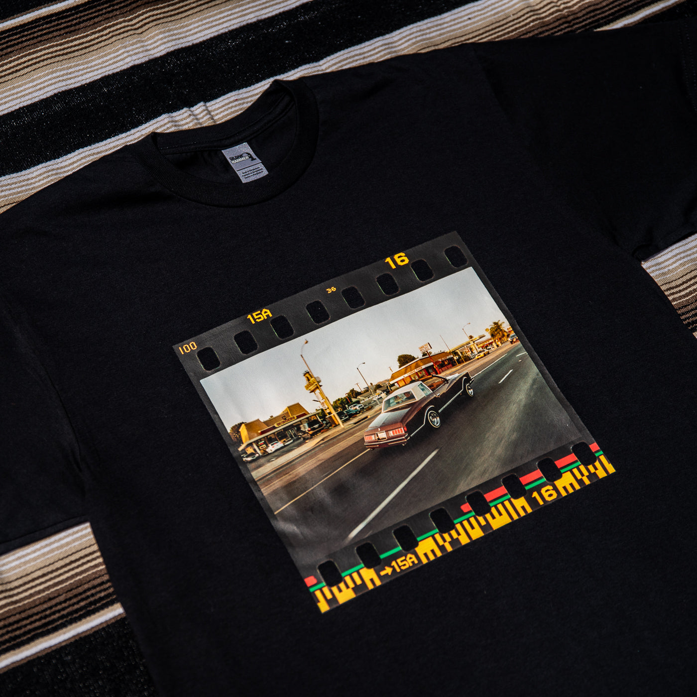 A black t-shirt with a photograph of a car on Washington Blvd printed in the center.