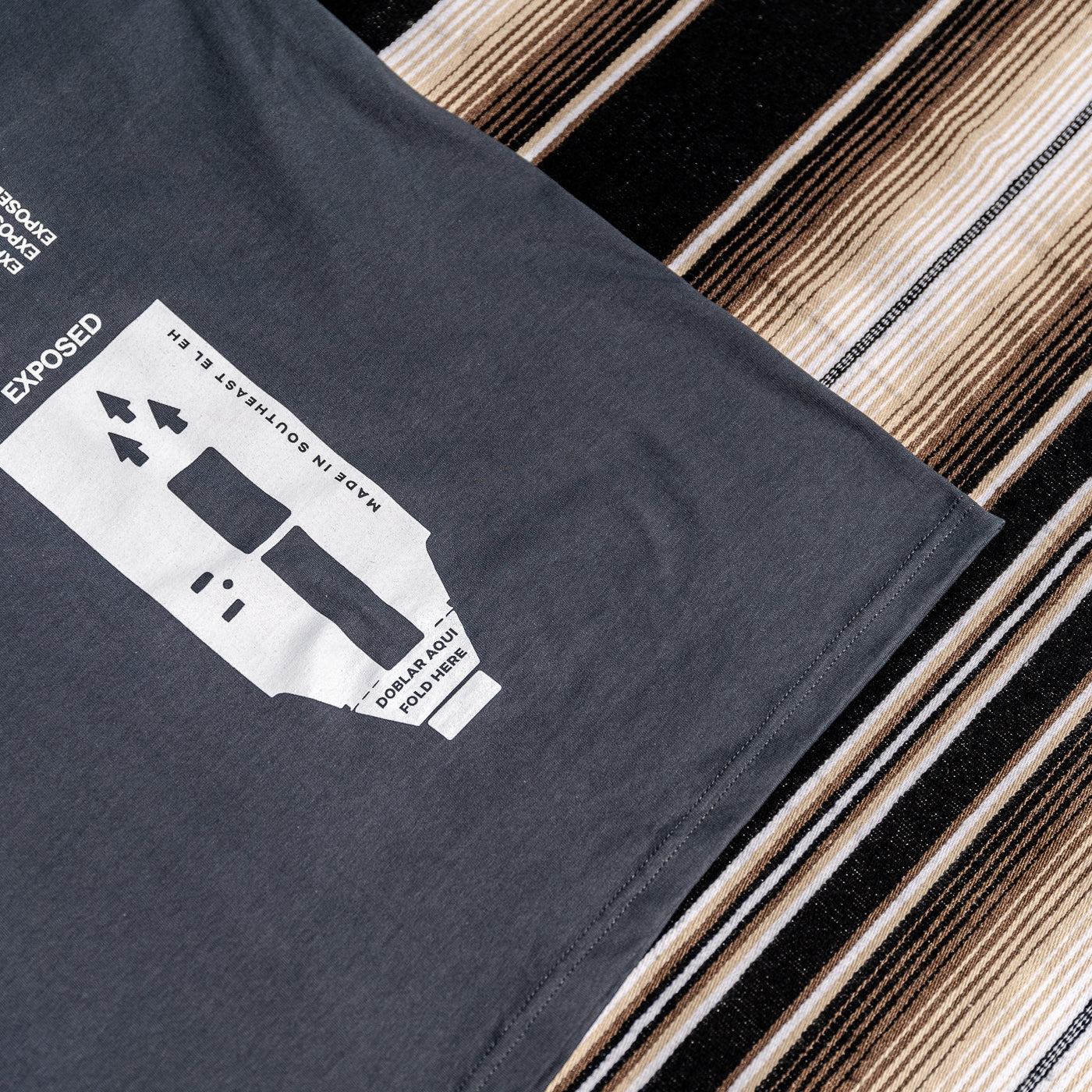 A gray t-shirt with a graphic print of a 35mm camera and the text 'EXPOSED".